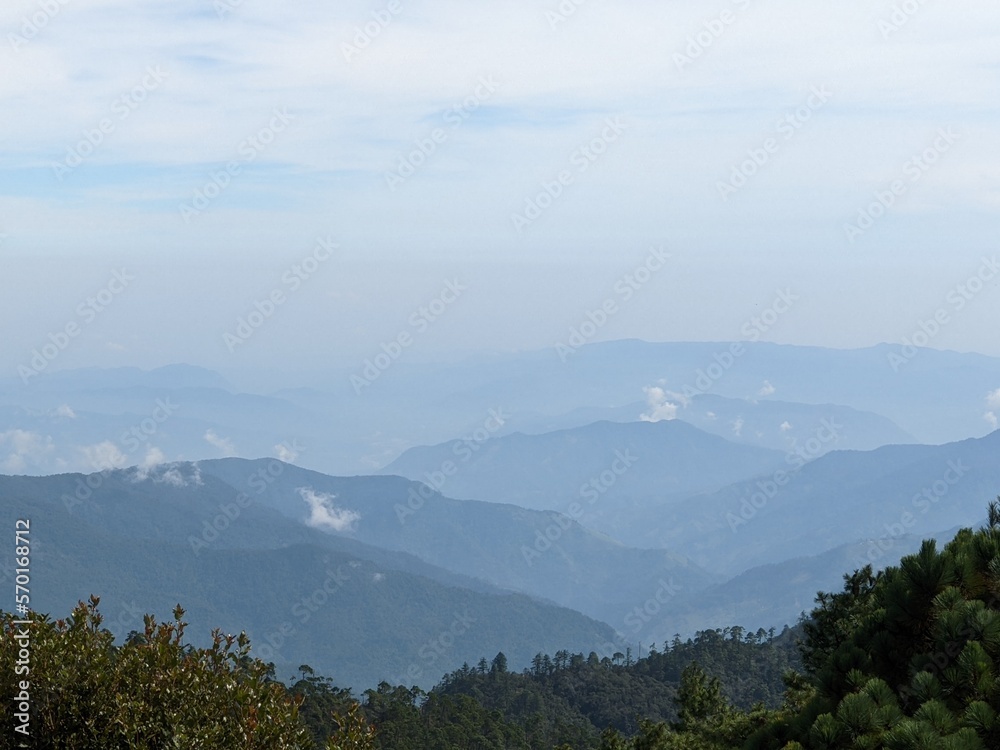 landscape of different mountains with clouds in the 
mountain range of oaxaca, mexico, blue sky morning, panoramic view
