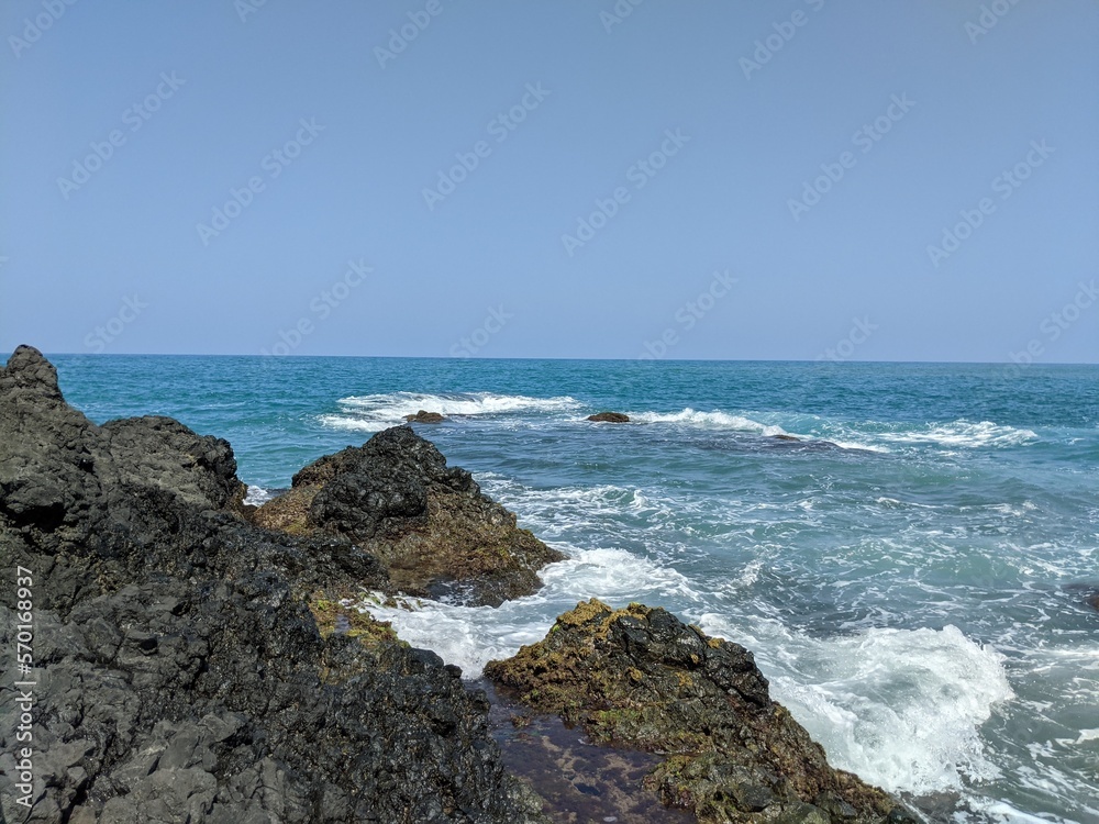 waves crashing on rocks with the sean in the backgroun in veracruz, mexico, landcape, holidays in latinoamerica, kelp in the cliffs