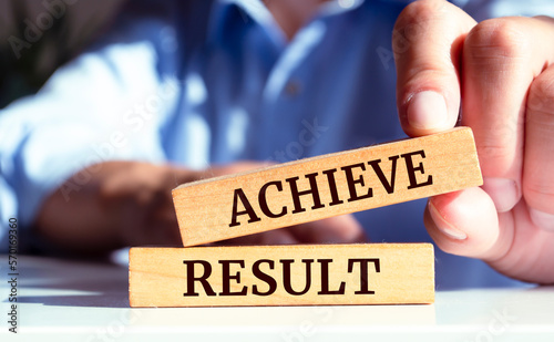 Wooden blocks with words 'ACHIEVE RESULT'.