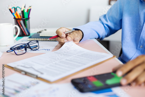 Close-up view on desk office, businessman reviewing document before signing a contract of investment or insurance, legal agreemen, working online via mobile phone photo