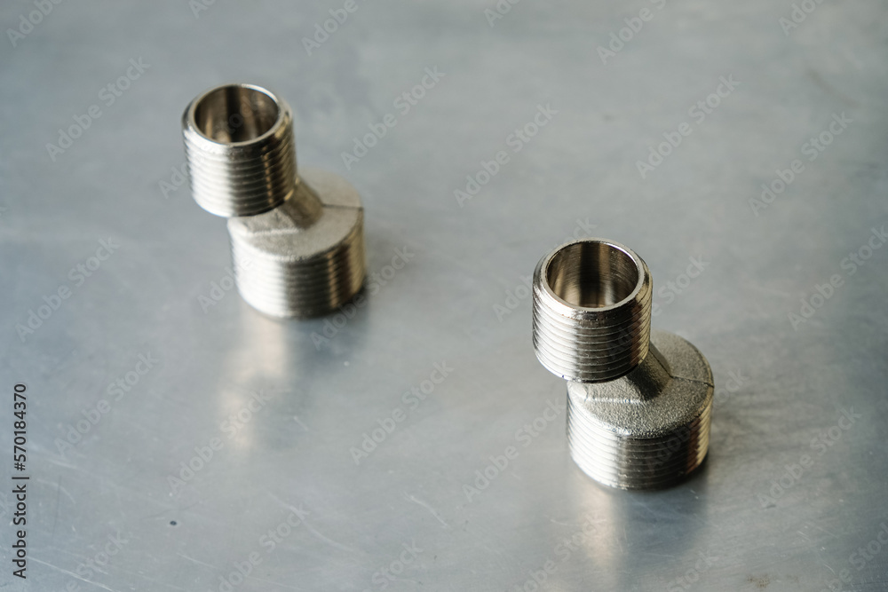 Steel eccentrics on the gray metal surface. Threaded fitting. Steel eccentrics on the gray metal surface. Threaded fitting.