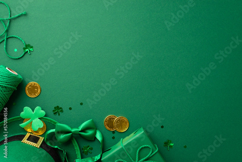 St Patrick's Day concept. Top view photo of leprechaun headwear giftbox with bow spool of twine gold coins bow-tie shamrock and trefoil shaped confetti on isolated green background with copyspace