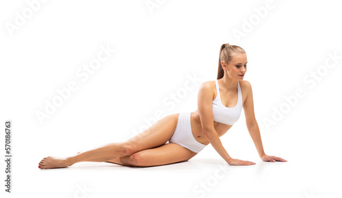 Young, fit and beautiful blond woman in white swimsuit isolated on grey background. Healthcare, diet, sport and fitness concept.