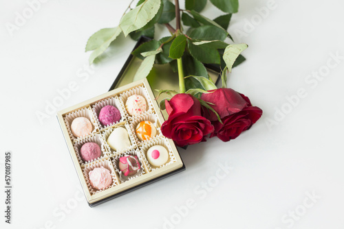 Chocolate truffle and roses on table, close up photo