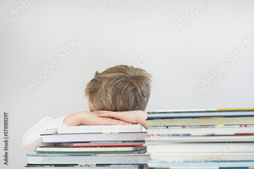 Boy sleeping on stack of books, close up photo