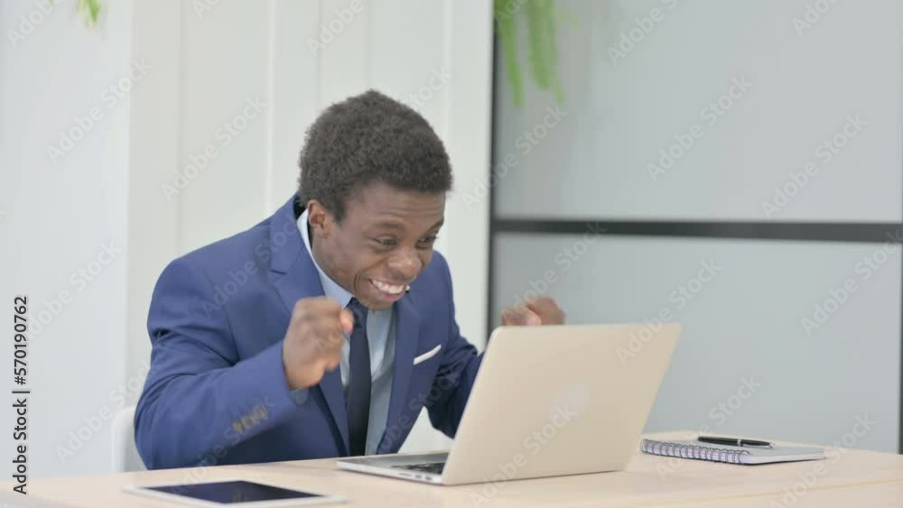 African Businessman Celebrating Online Success on Laptop in Office African Businessman Celebrating Online Success on Laptop in Office