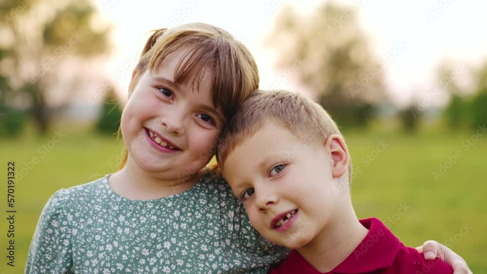 First Graders Smiling sister brother smiling while looking camera sunset. friendship portrait ...