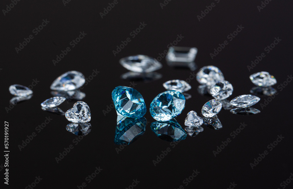 Blue and white polished diamonds of various cuts and sizes on black background. High quality photo Blue and white polished diamonds of various cuts and sizes on black background. High quality photo