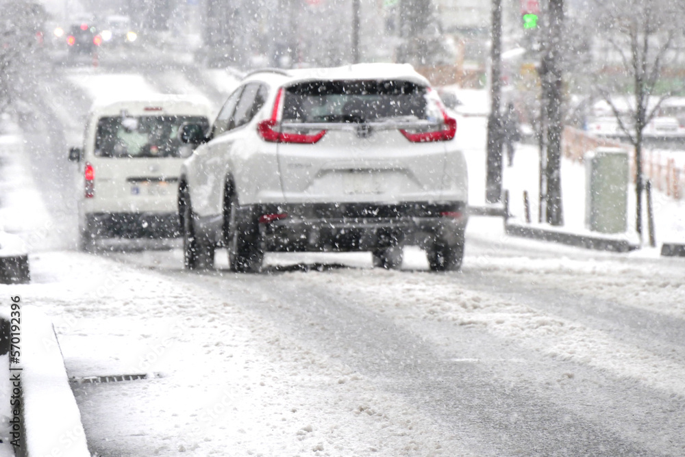 雪の日に市街地を走る車たち (Cars driving in the city on a snowy day)