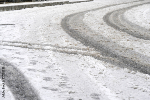 雪の日の市街地の道路、タイヤの痕 (Tire tracks on the city street on a snowy day)