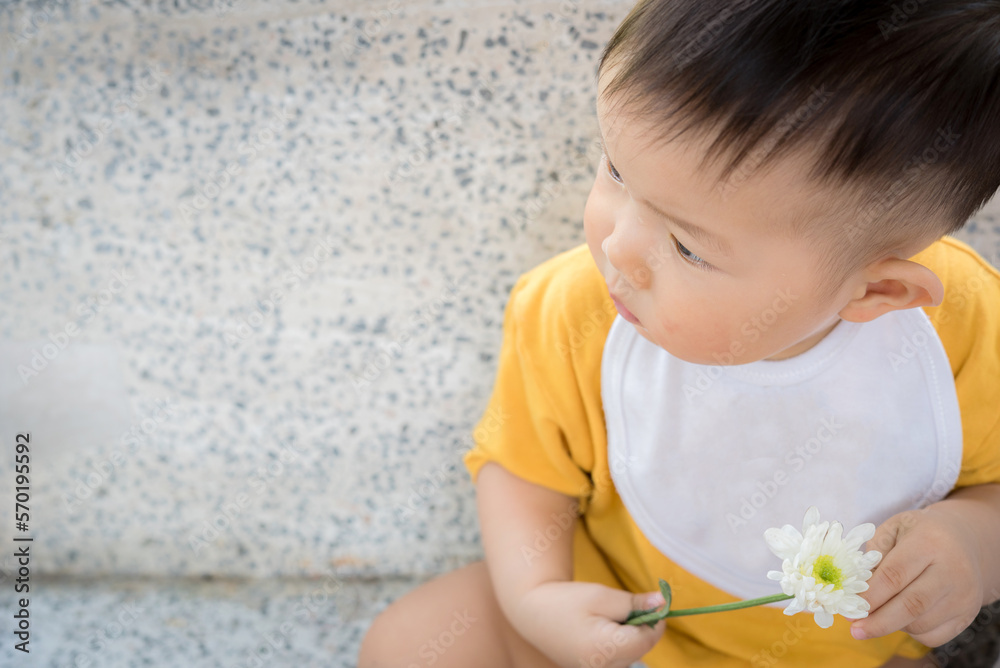 Fototapeta premium Asia cute baby boy holding white flower