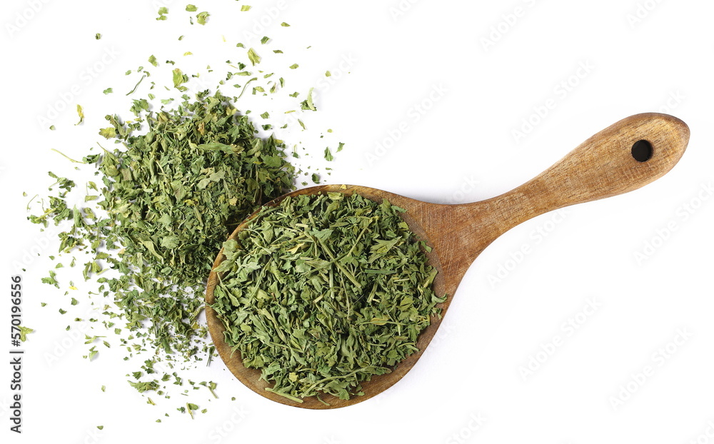 Chopped dry parsley leaves in wooden spoon, pile isolated on white, top view - obrazy, fototapety, plakaty 