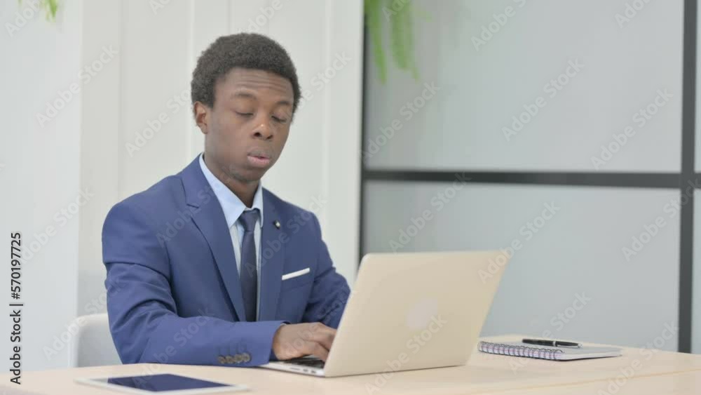 African Businessman Shocked While Working on Laptop African Businessman Shocked While Working on Laptop