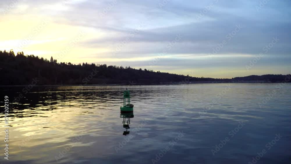 Dolly shot of metallic green buoy in sea against cloudy sky during sunset Dolly shot of metallic green buoy in sea against cloudy sky during sunset