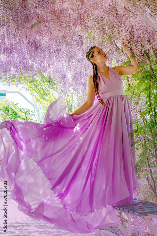 Fototapeta premium Woman wisteria lilac dress. Thoughtful happy mature woman in pur