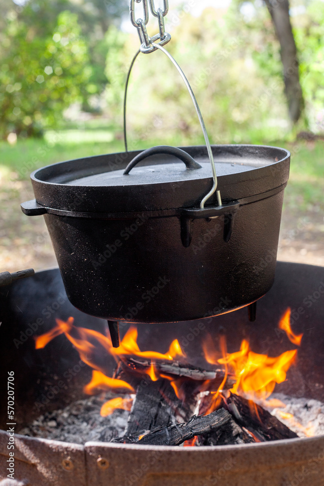 Close up of cast iron dutch oven hanging over open fire Close up of cast iron dutch oven hanging over open fire