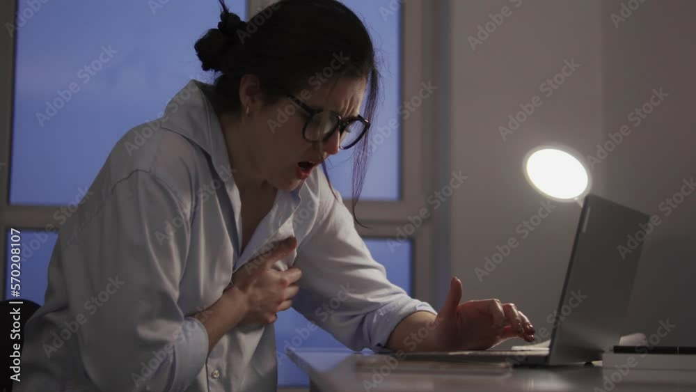 Overworked woman feeling pain in chest working on laptop in home office