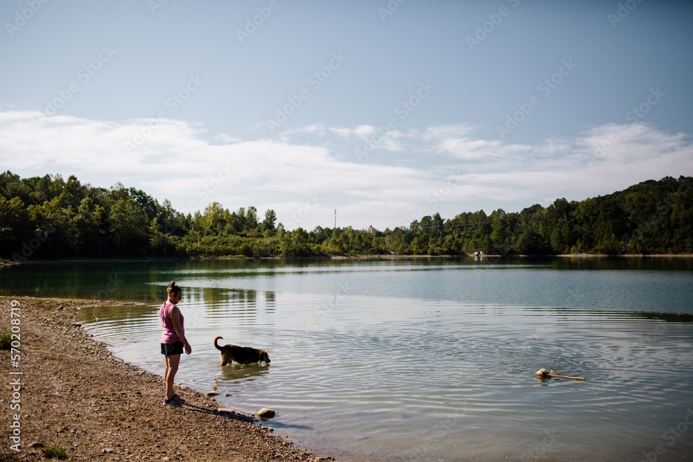 Woman Standing at Quarry While Dogs Swim in Cincinnati Woman Standing at Quarry While Dogs Swim in Cincinnati