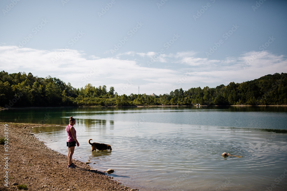 Woman Standing at Quarry While Dogs Swim in Cincinnati