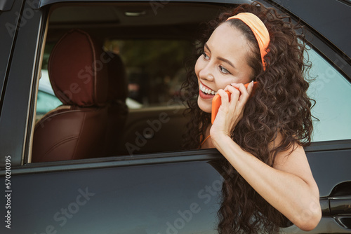 Billede på lærred The girl looks out of the car window and and talking by phone
