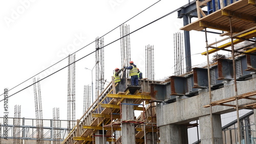 Builders at construction site outdoors in cloudy weather