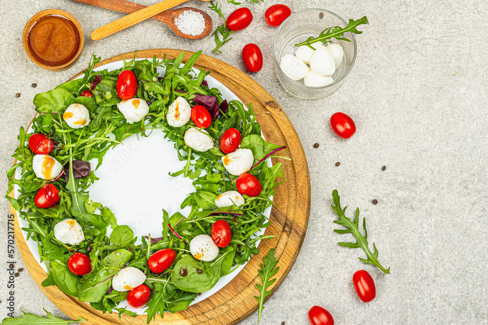 Charcuterie wreath made with mozzarella, cherry tomato, arugula. Fashionable snack, vegetarian food