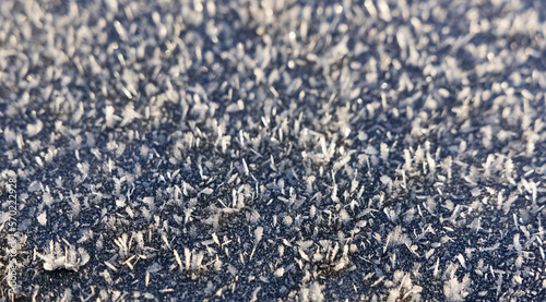Frost crystals on a smooth surface. Texture frozen background.