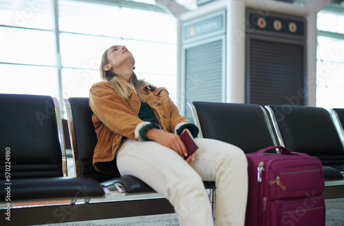 Bored woman, airport and luggage waiting with passport for missed flight, travel or vacation journey in Cape Town. Female traveler sitting in wait for delay departure, boarding plane or immigration