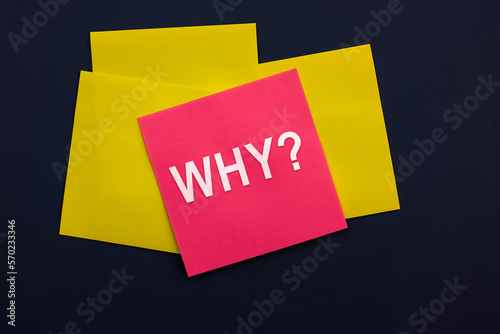 Why - inscription of a pink square sticky note paper on dark background. Top view. Business answer and analysis, problem ask, interrogation, research information concept