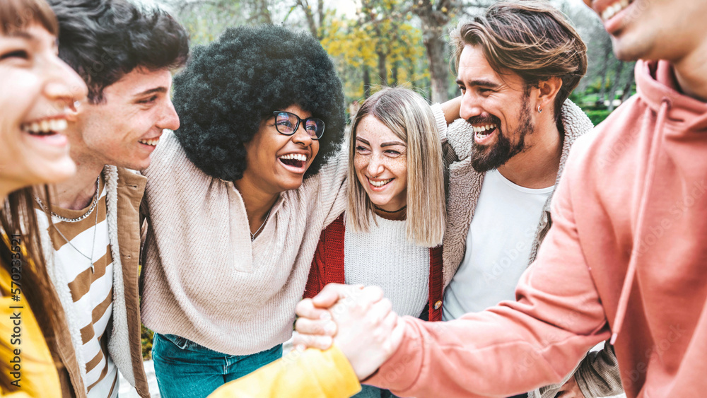 Obraz premium Multiracial happy friends having fun together outside - Group of young people enjoying day out - University students laughing and walking in college campus - Life style and youth concept