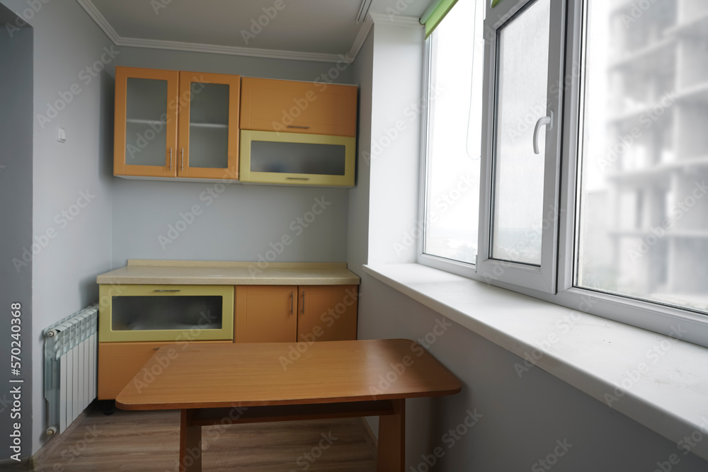 Empty kitchen table with wooden surface in foreground, brown modern countertop with drawers. blurred interior background. Empty kitchen table with wooden surface in foreground, brown modern countertop with drawers. blurred interior background.