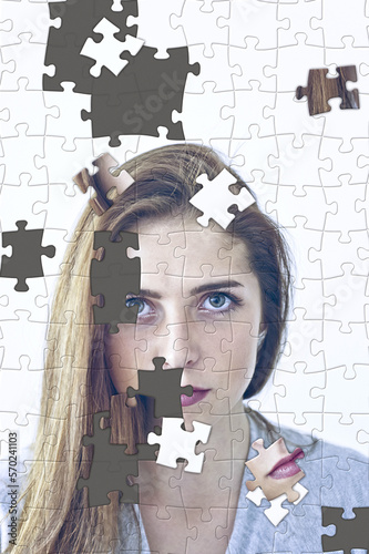 unfinished jigsaw puzzle with scattered pieces, of a woman face, psyche, psychology and shattered personal identity concept photo