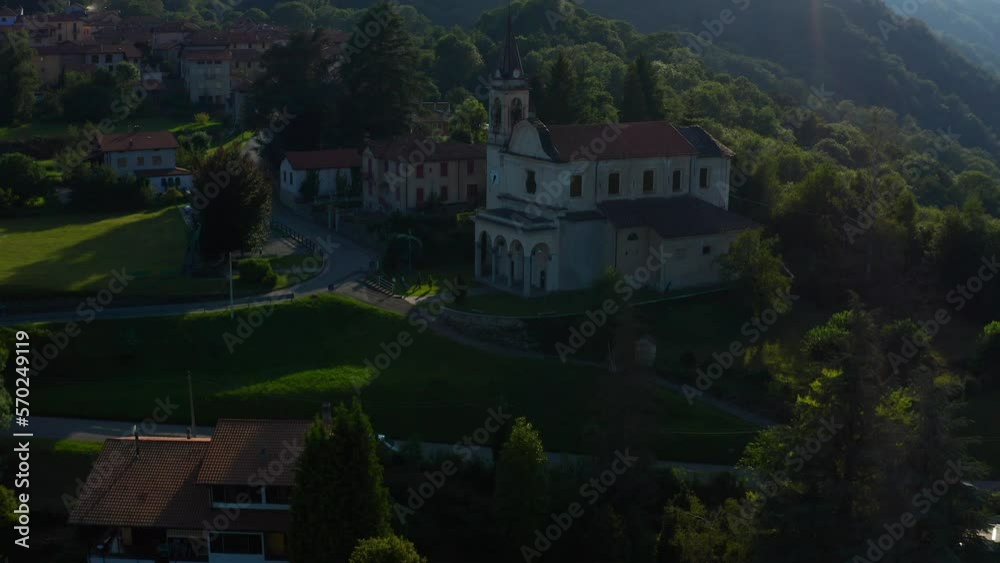 Aerial View Of Scenic Italian Village Parish Church Located Beside Forested Hills In Arola, Italy. Dolly Forward, Tilt Up. Establishing Shot Aerial View Of Scenic Italian Village Parish Church Located Beside Forested Hills In Arola, Italy. Dolly Forward, Tilt Up. Establishing Shot