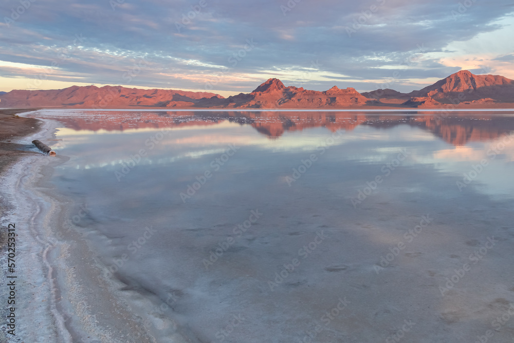 Scenic view of beautiful mountains reflecting in lake of Bonneville Salt Flats at sunrise, Wendover, Western Utah, USA, America. Looking at summits of Silver Island Mountain range. Romantic atmosphere