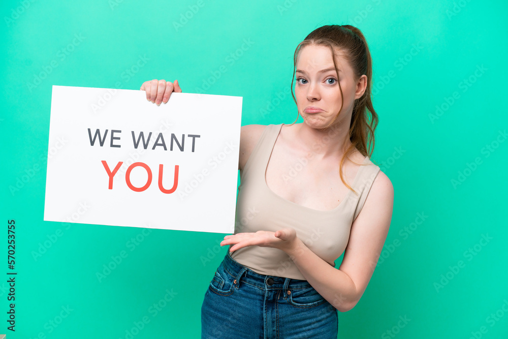 Young caucasian woman isolated on green background holding We Want You board and pointing it Young caucasian woman isolated on green background holding We Want You board and pointing it