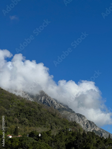 White clouds over the houses in the green mountains