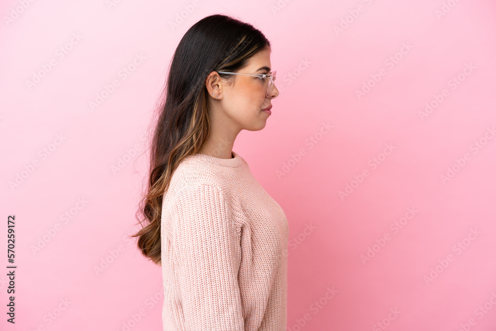 Fototapeta premium Young Italian woman isolated on pink background With glasses