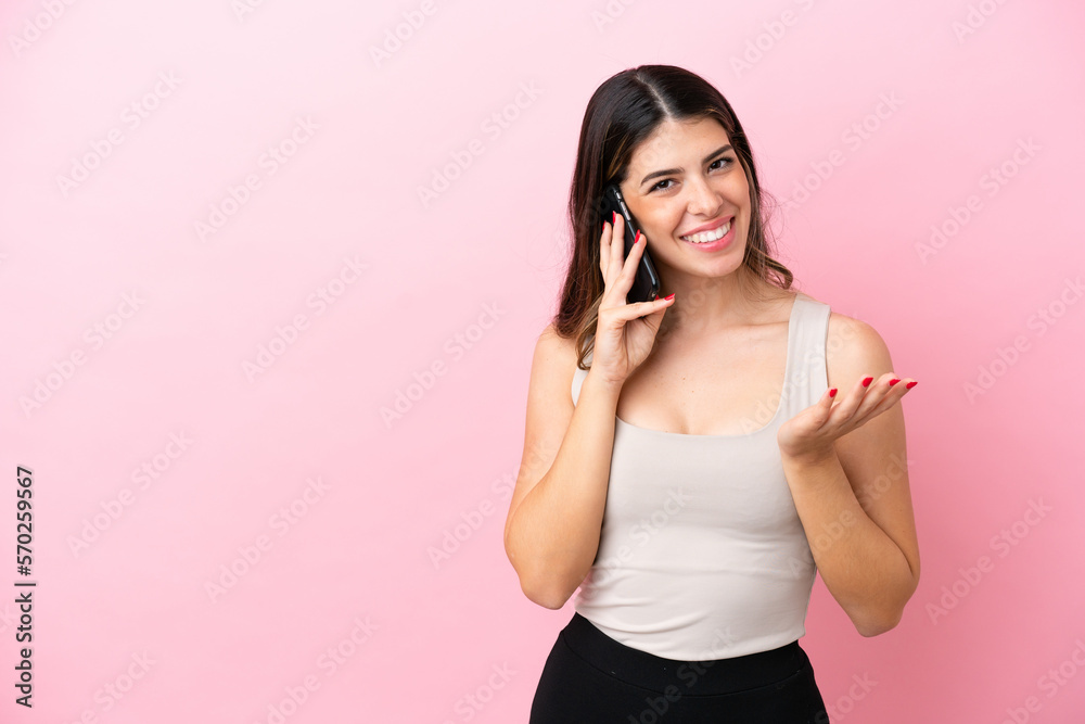 Young Italian woman isolated on pink background keeping a conversation with the mobile phone with someone Young Italian woman isolated on pink background keeping a conversation with the mobile phone with someone