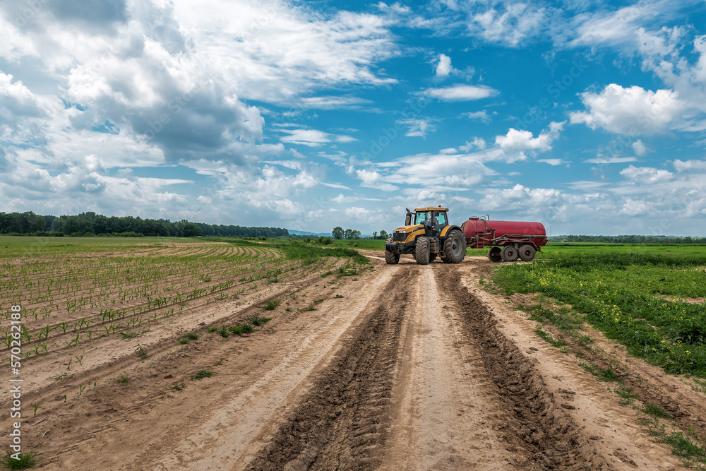 Tractor carries a barrel of herbicides on the corn field Tractor carries a barrel of herbicides on the corn field