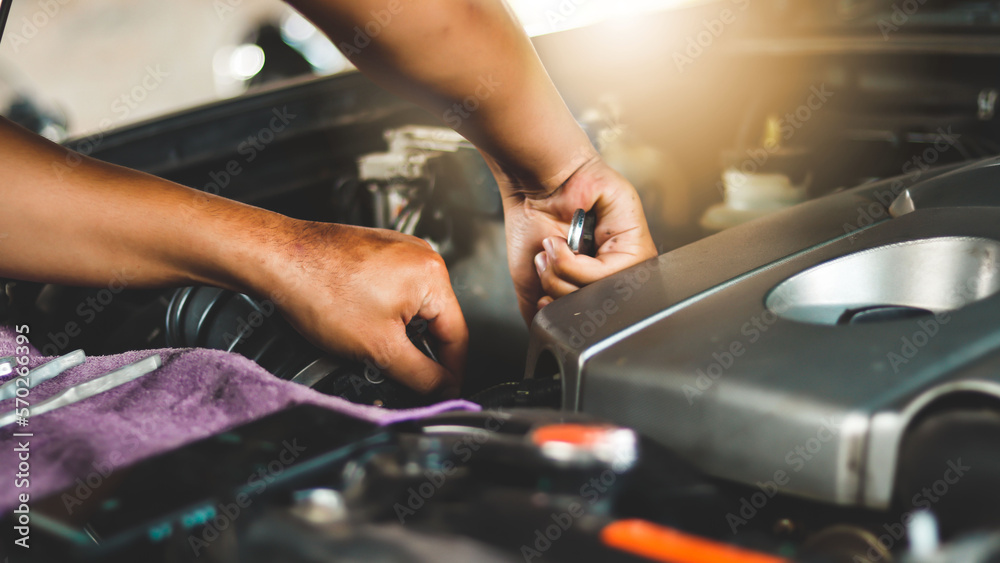A mechanic is checking the engine condition of a car that is being serviced for maintenance.