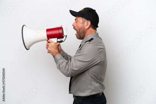 Middle age security man isolated on white background shouting through a megaphone