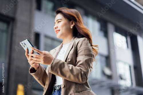 Business woman talking on mobile phone and smiling, Happy business woman, business woman with mobile phone in hand looking at camera, Image of pretty smiling woman in fashion