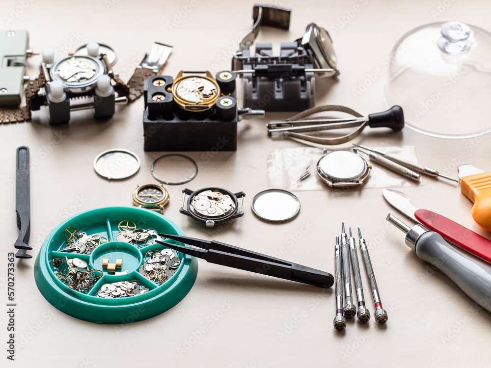 spare parts, tools and old watches on wooden table in watchmaker workshop spare parts, tools and old watches on wooden table in watchmaker workshop