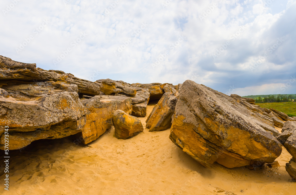 heap of huge stones lie on sandy hill under dense cloudy sky, wild sandy desert landscape heap of huge stones lie on sandy hill under dense cloudy sky, wild sandy desert landscape