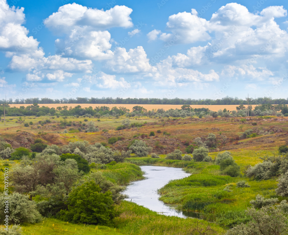 small river flow among a prairie under blue cloudy sky small river flow among a prairie under blue cloudy sky