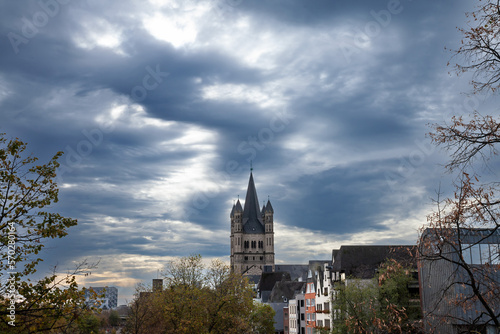Main tower of the Gross Sankt Martin Kirche seen from afar in a cologne landscape during a cloudy afternoon. The Great Saint Martin Church is a Roman catholic medieval church in Cologne  Germany.