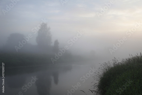 Morning rural landscape with fog over the river.