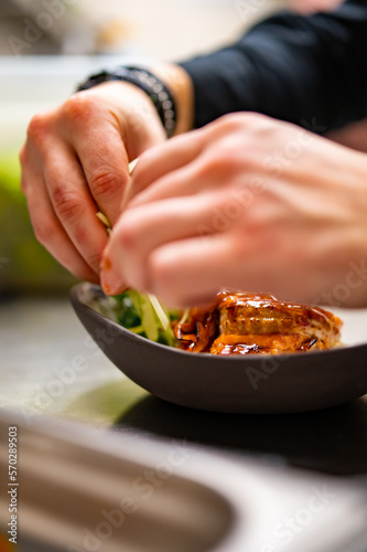 chef hand cooking donburi bowl food in the restaurant kitchen