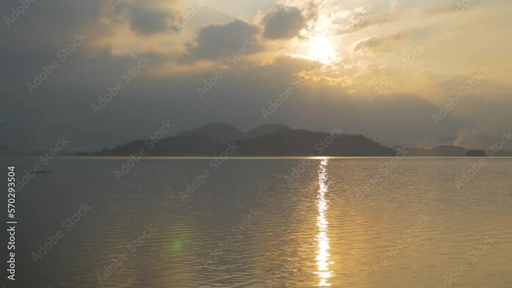 Sunset reflecting on the lake water with an island in the distance, in Vietnam Sunset reflecting on the lake water with an island in the distance, in Vietnam
