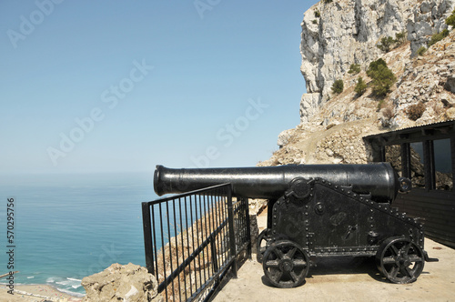 A north facing ancient black military cannon situated on Gibraltar's Upper Rock Nature Reserve, that once protected Gibraltar from invasion, which looks out over the Mediterranean Sea. 